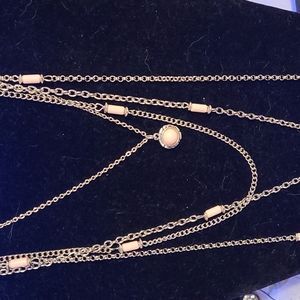 long multi strand pink and silver necklace with a key
